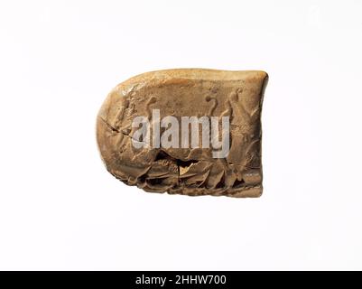 Cuneiform tablet impressed with seals: administrative document inscribed in Achaemenid Elamite ca. 500 B.C. Achaemenid This tongue-shaped clay tablet is round on one side and straight on the other. An Elamite cuneiform text covers much of the surface; impressions of cylinder seals appear on the reverse and flat sides of the tablet. The impression on the reverse shows a hero holding a winged lion creature on either side of him by its hind leg. The impression on the flat side is difficult to make out, but may show a bearded man with long hair.The Elamite text reads:60 rams, 75 ewes, 20 intermedi Stock Photo