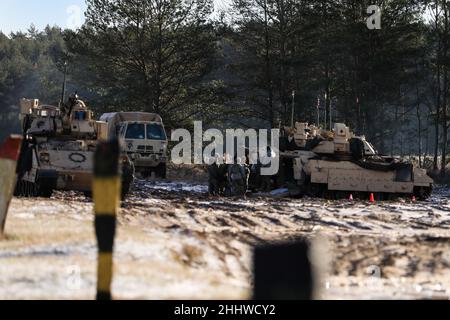 Infantry Soldiers assigned to Charlie Company “Fighting Aces,” of 2nd Battalion, 34th Armored Regiment, 1st Armored Brigade Combat Team, 1st Infantry Division, perform checks on the vehicles after the gunnery Table VI qualification on the Bradley Fighting Vehicles at Konotop Range, Drawsko Pomorskie Training Area, Poland, January 22, 2022. After a qualification, crews identify, diagnose and fix any malfunctions discovered during the event. (U.S. Army photo by Staff Sgt. Gabriel Rivera) Stock Photo