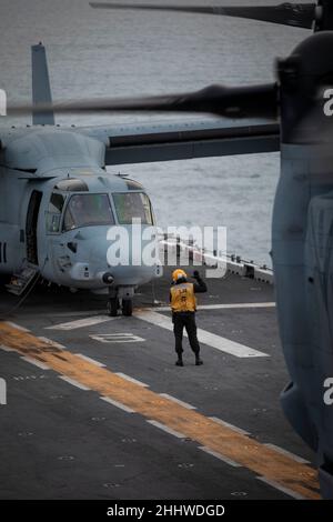 An Aviation Boatswain's Mate 3rd Class directs an F/A-18 Super Hornet ...