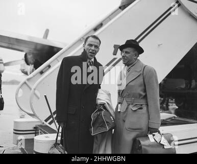 Singer Frank Sinatra seen here with Sunday People journalisrt Arthur Helliwell about to board a TWA flight to New York at London Airport . Circa December 1952 Stock Photo