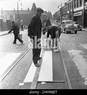 Council workers re-painting a worn out zebra crossing on High Street West, Sunderland 28th April 1954 Stock Photo