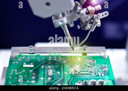 High technology and modern automatic robot for print circuit board (PCB)assembly machine during soldering or welding part or component at factory Stock Photo