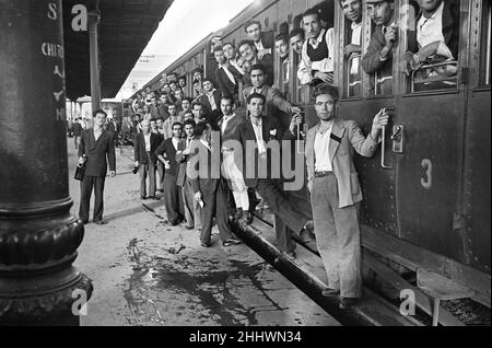 Scenes in Naples, southern Italy showing  men arriving at the railway station, headed for their work on the docks. Circa 1955. Stock Photo