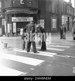 Council workers re-painting a worn out zebra crossing on High Street West, outside the Empire Theatre, Sunderland 28th April 1954 Stock Photo