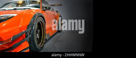 Front headlights of orange modify car on black background, copy space Stock Photo