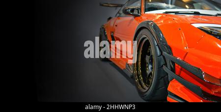 Front headlights of orange modify car on black background, copy space Stock Photo