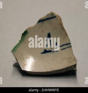 Fragment 9th century. Fragment. 9th century. Earthenware; opaque white glaze, green splashed glaze, inscription in blue. Attributed to Iraq. Excavated in Iran, Nishapur. Ceramics Stock Photo