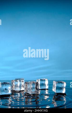 Ice cubes in bright blue water and a splash of raindrops Stock Photo