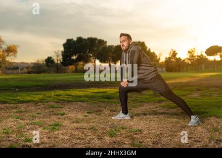 Determined athlete exercising on lawn during running training Stock Photo