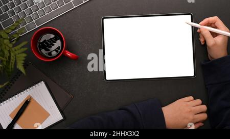 Overhead shot of a female using, working, drawing, sketching graphic on digital tablet computer on modern dark workspace. Stock Photo