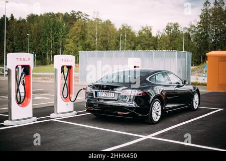 Black Color Tesla Model S 100d Car Parked At Charging Station. The Tesla Model S Is A Full-sized All-electric Five-door, Luxury Liftback, Produced By Stock Photo
