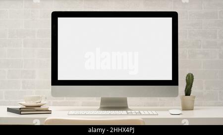 Minimal contemporary office workstation with desktop computer mockup and accessories on table over white brick wall. Stock Photo