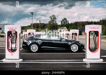 Black Color Tesla Model S 100d Car Parked At Charging Station. The Tesla Model S Is A Full-sized All-electric Five-door, Luxury Liftback, Produced By Stock Photo