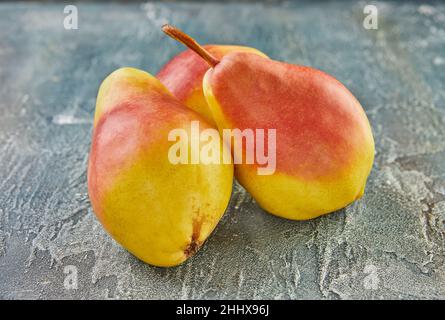 Fresh pears on blue background. Background of beautiful homemade pears. Stock Photo
