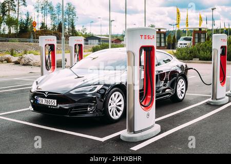 Black Color Tesla Model S 100d Car Parked At Charging Station. The Tesla Model S Is A Full-sized All-electric Five-door, Luxury Liftback, Produced By Stock Photo