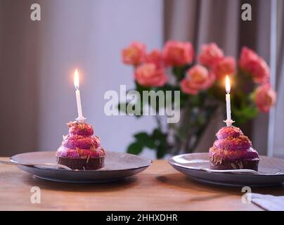 Berlin, Germany. 12th Jan, 2022. ILLUSTRATION - Two cupcakes with burning candles are placed on a table. (posed scene) Credit: Annette Riedl/dpa/Alamy Live News Stock Photo