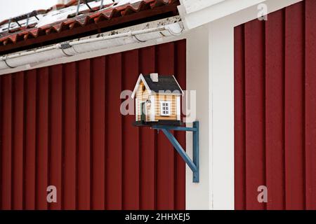 Umea, Norrland Sweden - November 13, 2019: small yellow model house stuck on the gable of a real house Stock Photo