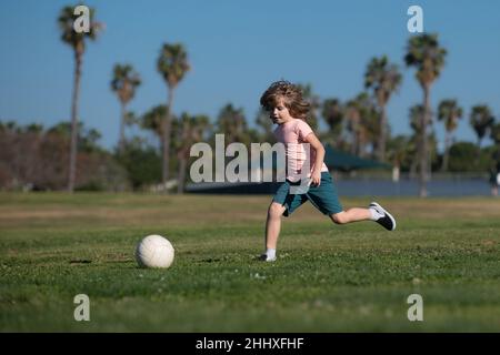 Soccer kid. Kids play football on outdoor stadium field. Little boy kicking ball. School football sports club. Training for sport children. Kids play Stock Photo