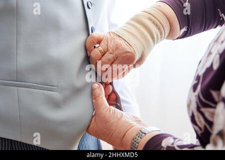 A mom helps her son get ready for the wedding Stock Photo