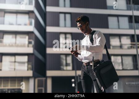 Young african american businessman texting from his smartphone on the street Stock Photo