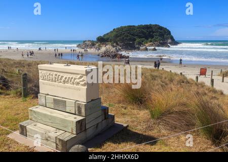 The beach at Mount Maunganui, New Zealand. In the foreground is a sculpture depicting the rescue of penguins from the 2011 MV Rena oil spill Stock Photo