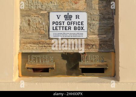 A brass letterbox with the crown and cypher of Queen Victoria. Photographed at the historic 1886 post office in Ophir, New Zealand Stock Photo