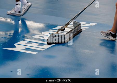 Melbourne, Australia. 26th Jan, 2022. Tennis: Grand Slam - Australian Open. A woman dries the floor of a court at Melbourne Park. Credit: Frank Molter/dpa/Alamy Live News Stock Photo