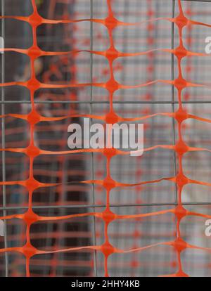 Construction site protected with orange barrier net and welded wire. Closeup Stock Photo