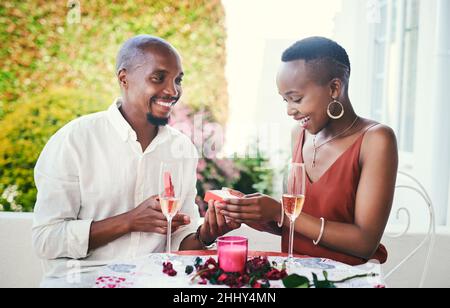 You deserve the best, babe. Cropped shot of a happy young couple having a romantic dinner outside. Stock Photo