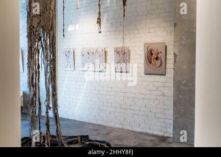 Image of modern studio with beautiful painted pictures hanging on brick wall Stock Photo