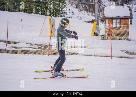 Ski instructor at training track showing students how to ski Stock Photo