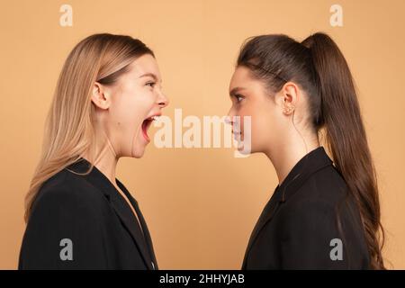 Boss yelling at employee. Colleague screaming on worker. Bulling on work. One woman shouting another woman facing each other face to face standing iso Stock Photo