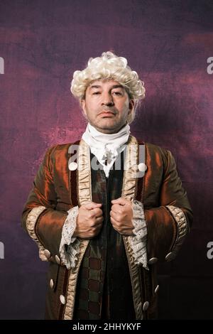 Man in classical renaissance clothing posing while looking at the camera with a serious expression on his face. Stock Photo