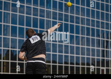 male athlete shot put on background glass facade Stock Photo