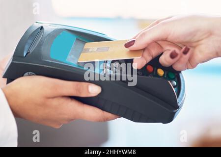 Tap and go. Cropped shot of a customer using her credit card to make a payment. Stock Photo