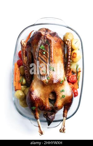 Baked  Christmas goose stuffed with apples served with baked vegetables isolated on white Stock Photo