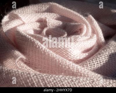 Extra soft handwoven fabric pf pale pink color. Draped lightweight mohair shawl or blanket, close up Stock Photo