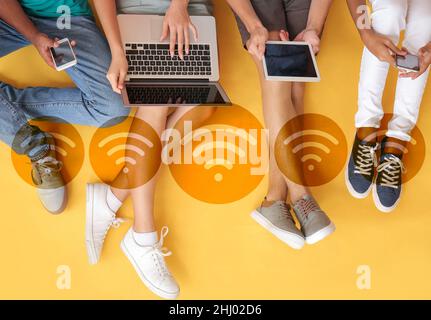Teenagers with different devices using wi-fi on color background, top view Stock Photo