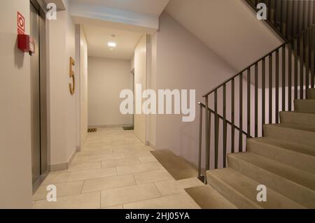 Hallway and staircase in an apartment building with entrance doors to flats Stock Photo