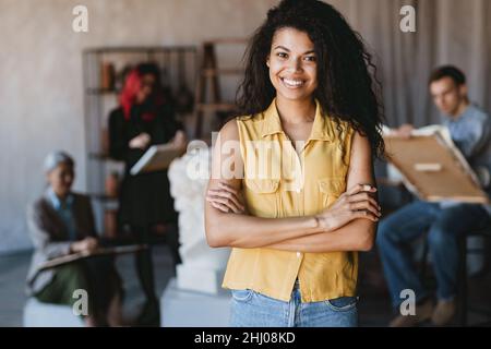 Young student woman smiling at camera during class in art school indoors Stock Photo