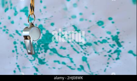 Whistle of soccer referee or trainer on paint splashes background. Great soccer event, soccer championship concept Stock Photo