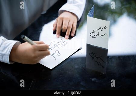 Close up of a child's hand writing a greeting card Stock Photo