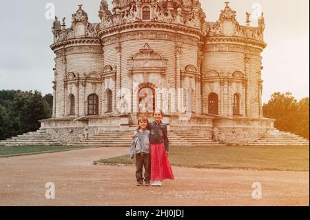 Moscow, Dubrovitsy 06.29.2021 two happy little kids siblings traveler on background of exterior of Orthodox building church temple of Gothic architect Stock Photo