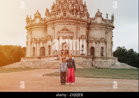 Moscow, Dubrovitsy 06.29.2021 two happy little kids siblings traveler on background of exterior of Orthodox building church temple of Gothic architect Stock Photo