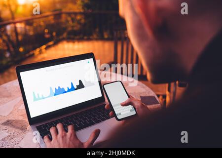 business man using wireless internet connection on netbook and mobile for analyzing diagram Stock Photo
