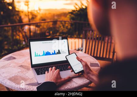 Anonymous man typing on laptop on terrace Stock Photo