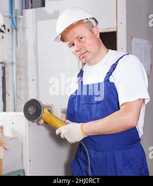 Contractor using angle grinder Stock Photo