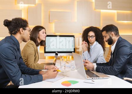 Young coworkers. Young modern woman in smart casual wear working with her coworkers while spending time in the office. Attractive woman looking at her colleague Stock Photo