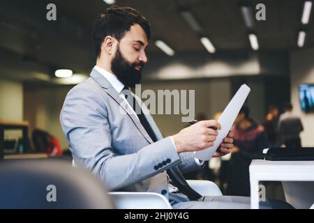 Focused entrepreneur reading documents in office Stock Photo