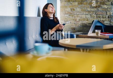 Laughing student reading message on mobile phone Stock Photo